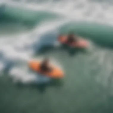 An aerial view of individuals sledding on boogie boards in powerful waves.