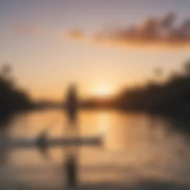 Paddleboarder gliding across calm waters at sunset