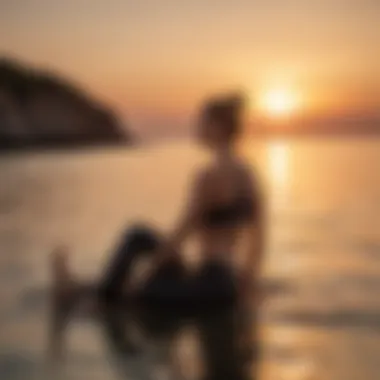 A practitioner engaging in the Cobra pose with a backdrop of a sunset over water