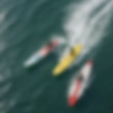 An aerial photograph of surfers using fiberglass boards in vibrant ocean waves.