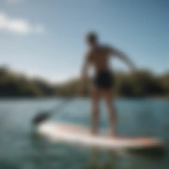 A person gracefully mounting a paddleboard in calm waters