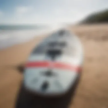 A sleek kitesurf board resting on the sandy beach