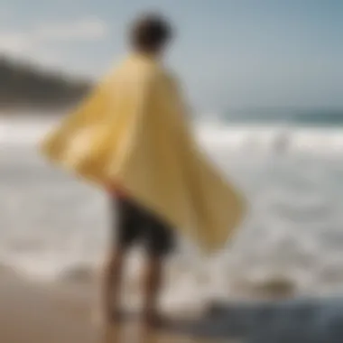 A surfer using a towel poncho for a quick change after a surf session, highlighting convenience.