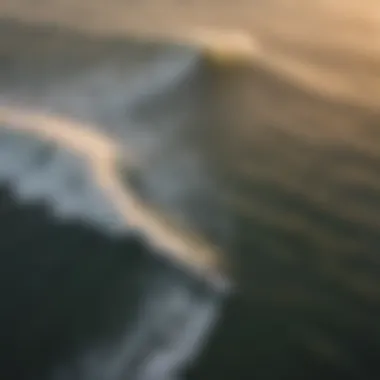 An aerial view of surfers riding waves during sunset