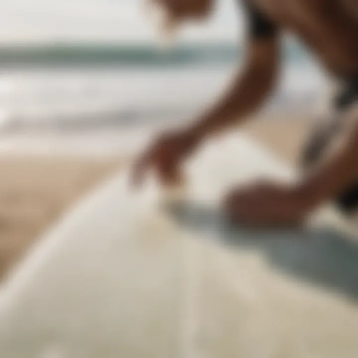 A surfer applying wax to a surfboard using a surf wax comb