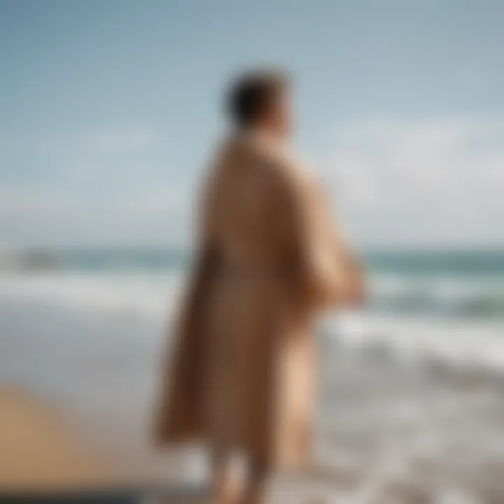 A surfer wrapped in a dry robe on a beach after a session