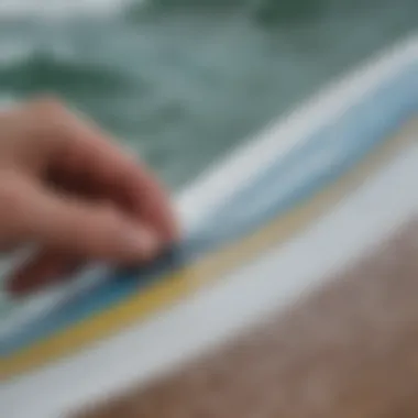 Close-up of a vinyl sticker being applied to a surfboard